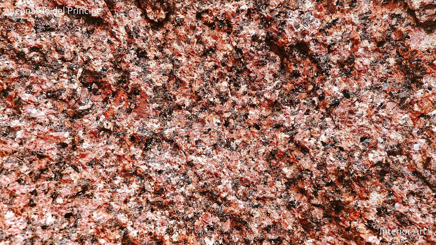 ABGR01 close-up and abstract view of textured pink granite, featuring a mix of pink, black, and white speckles. The surface is rough, conveying a natural, earthy feel.