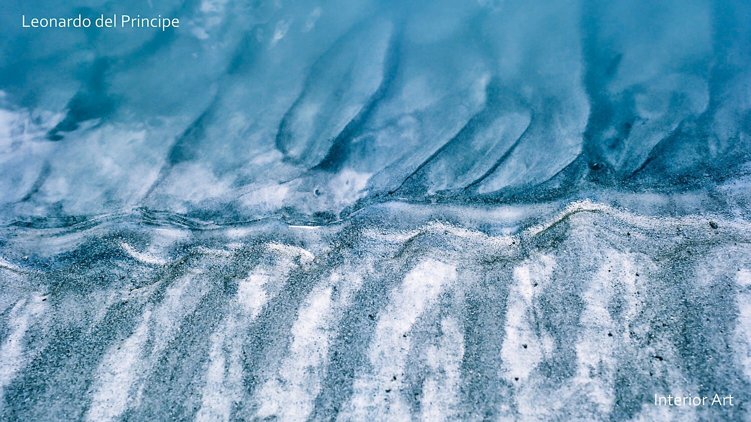 PARI03 Abstract film-based photography depicting swirling, textured patterns in blue and white, resembling sand beneath a gentle tide of a creek. The mood is calm and...